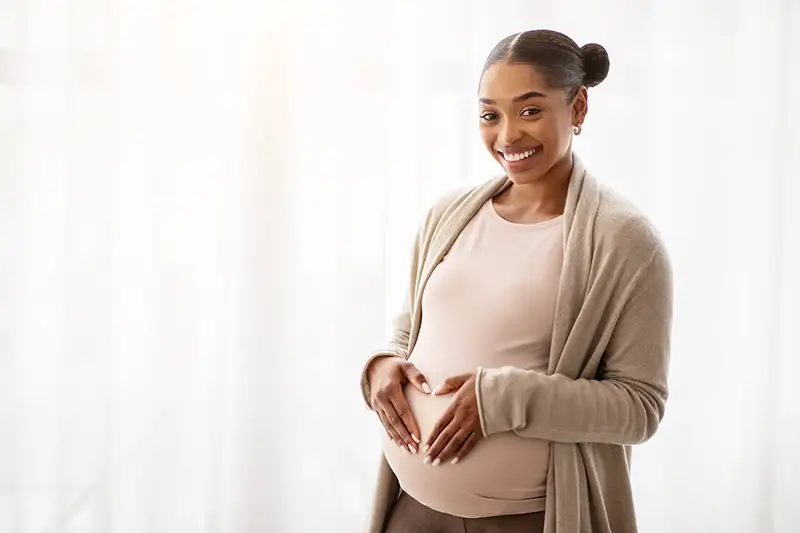 Close-up of a pregnant belly, representing the physical qualifications required to become a gestational carrier