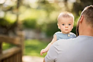 Intended parent holding their baby, reflecting the connection and care created through surrogacy