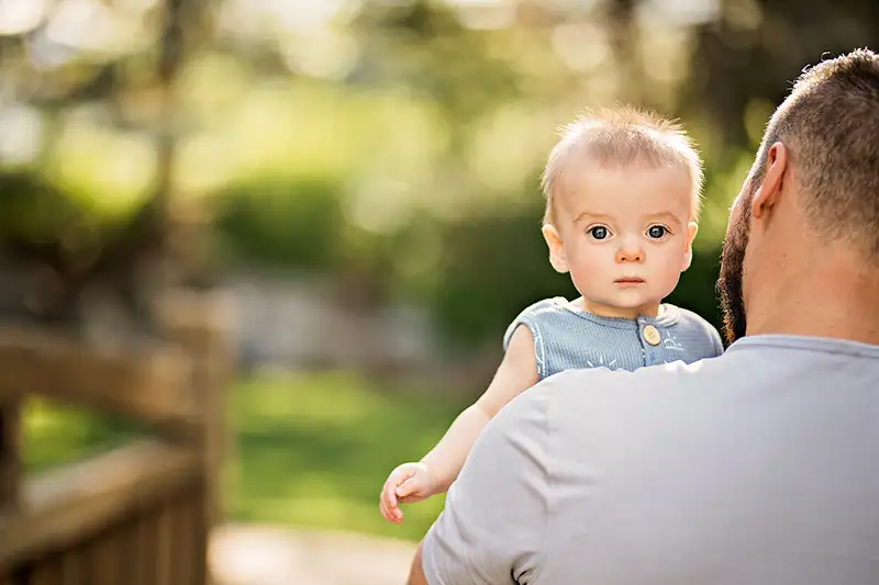 Intended parent holding their baby, reflecting the connection and care created through surrogacy