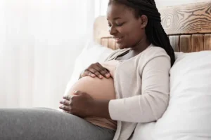 Gestational carrier resting comfortably, representing care, respect, and understanding in modern surrogacy